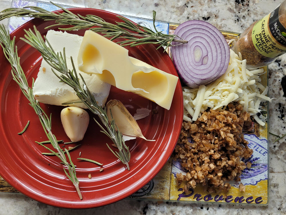 Chopped mushrooms, raw onion, minced garlic, cheese, cayenne pepper on a tray