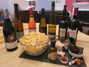 Bowl of popcorn with many different bottles of wine